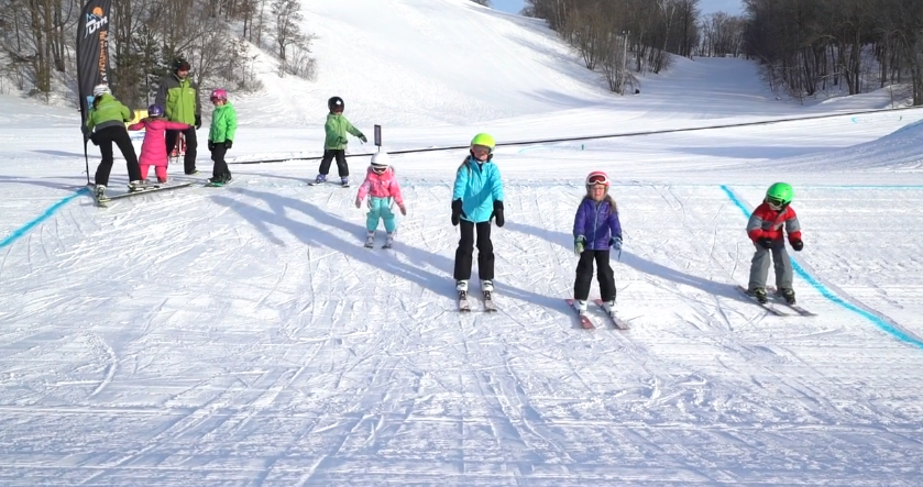 kids skiing in line during lesson