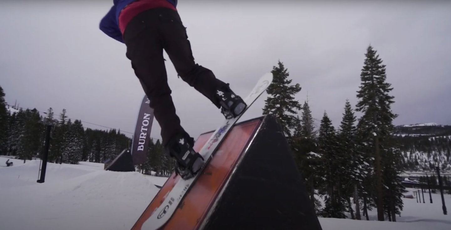 snowboarder riding on rails