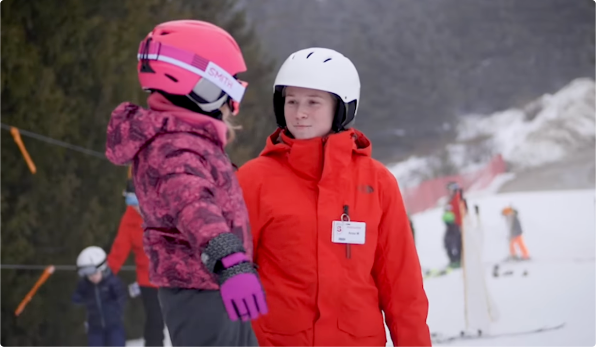 skiing instructor helping child