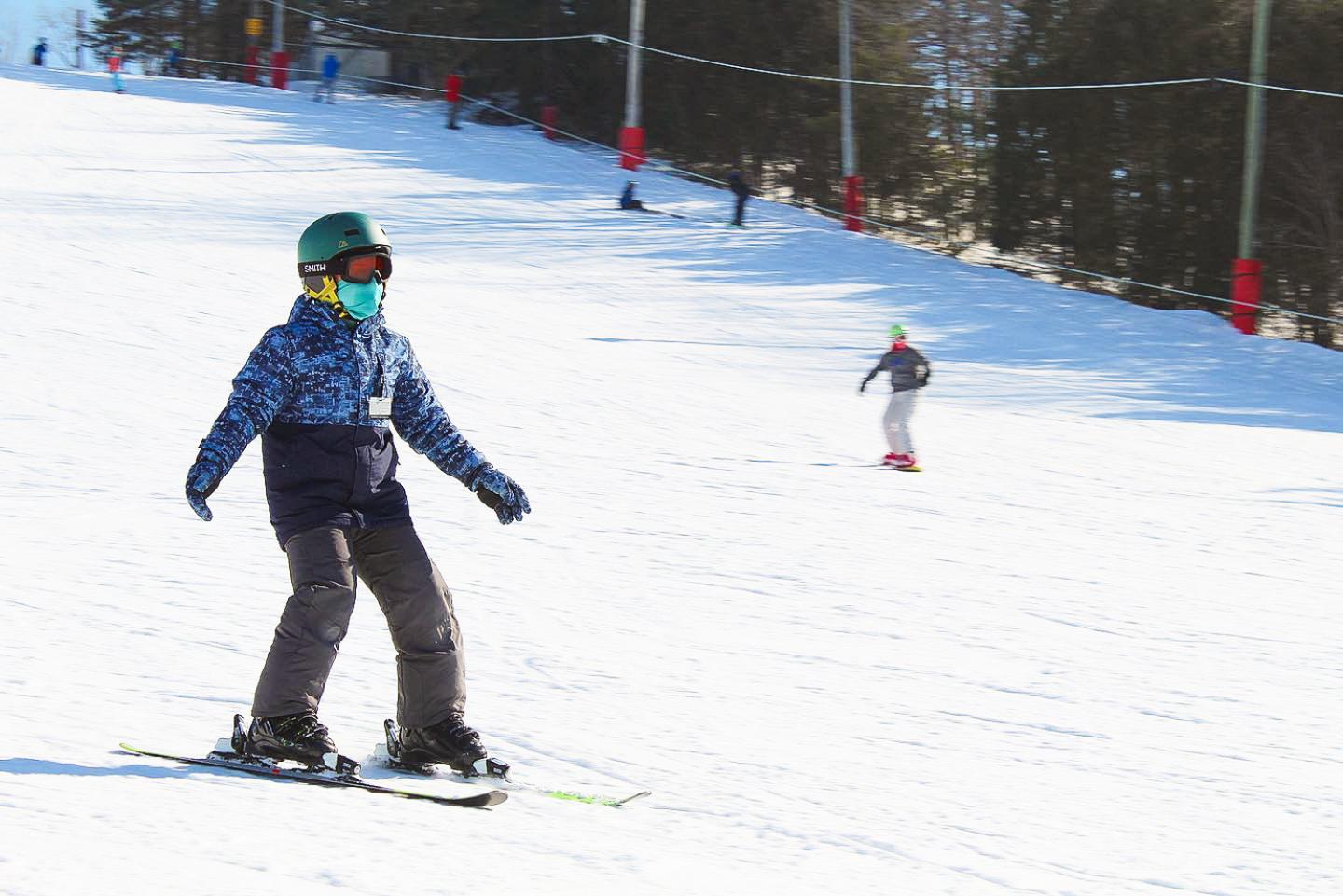 child skiing down hill