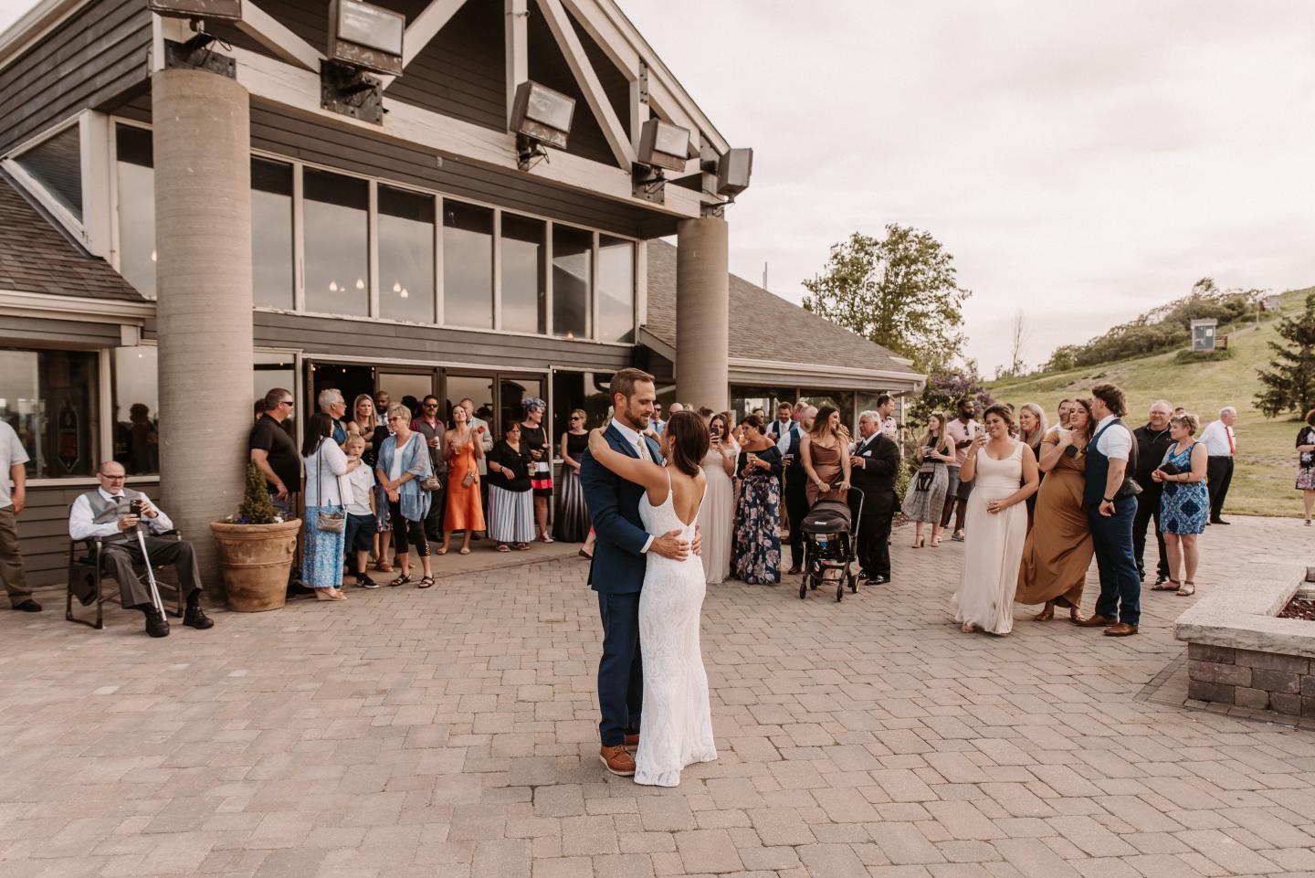 bride and groom sharing first dance outside ski lodge wedding venue