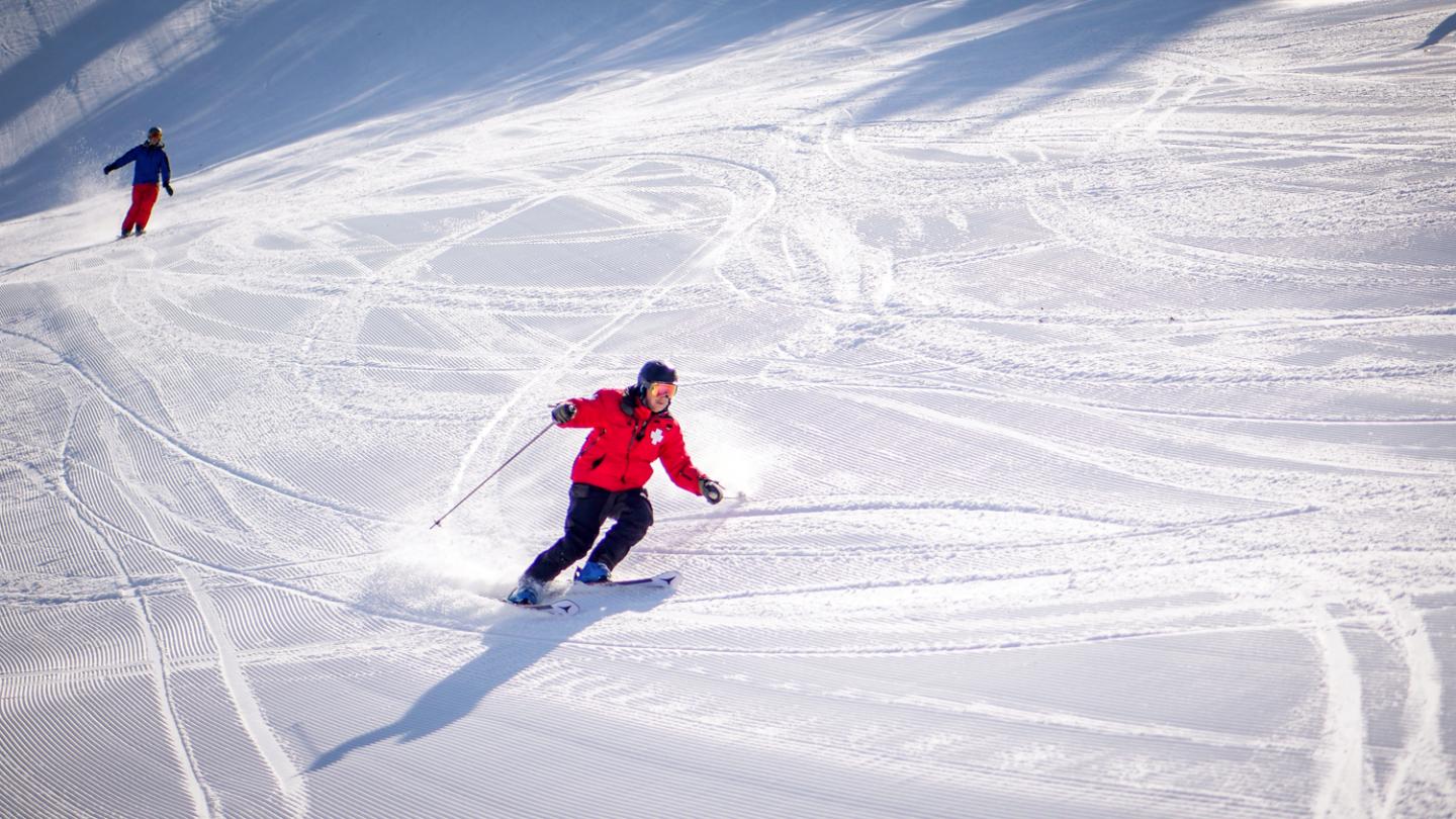 ski patroller skiing down mountain