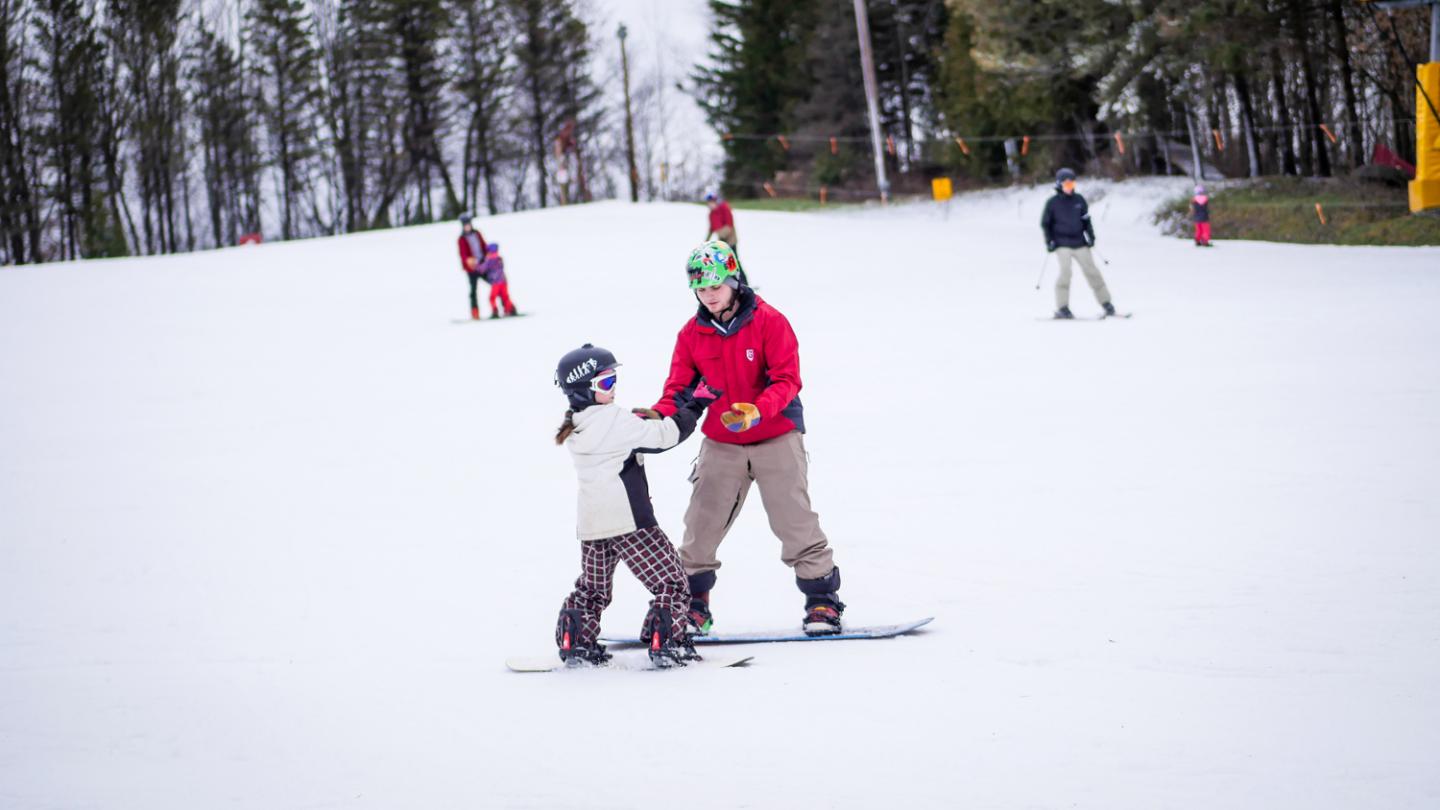 ski instructor giving child a ski lesson