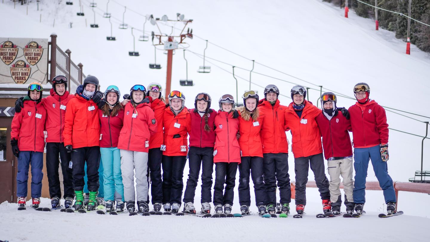 group of ski instructors standing together and smiling