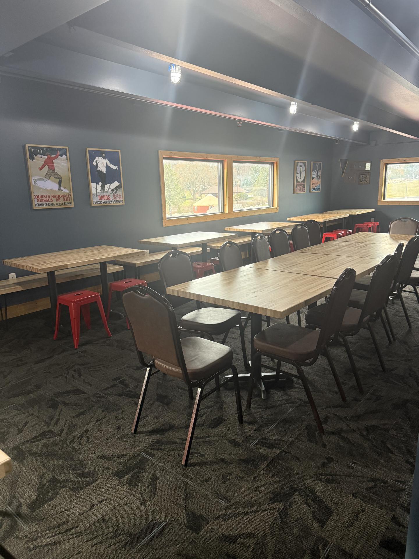 Sunny dining area with long wooden tables and chairs.