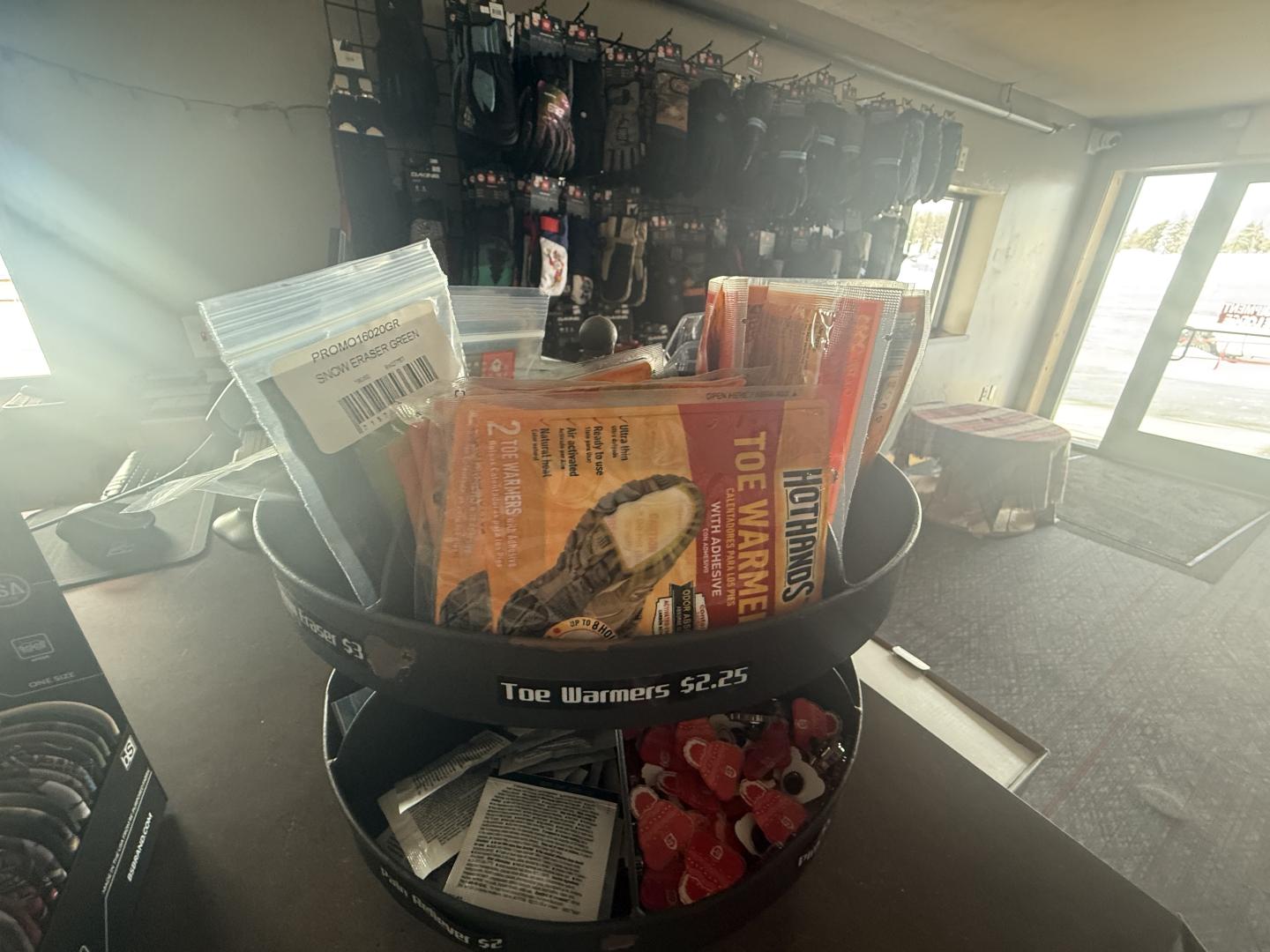 Store display of hunting gear and accessories by a window, with sunlight streaming in.