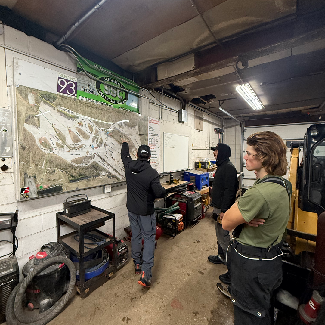 People studying a map on a garage wall.