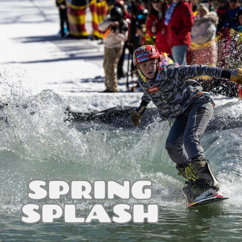 Snowboarder splashes through icy water as onlookers watch.