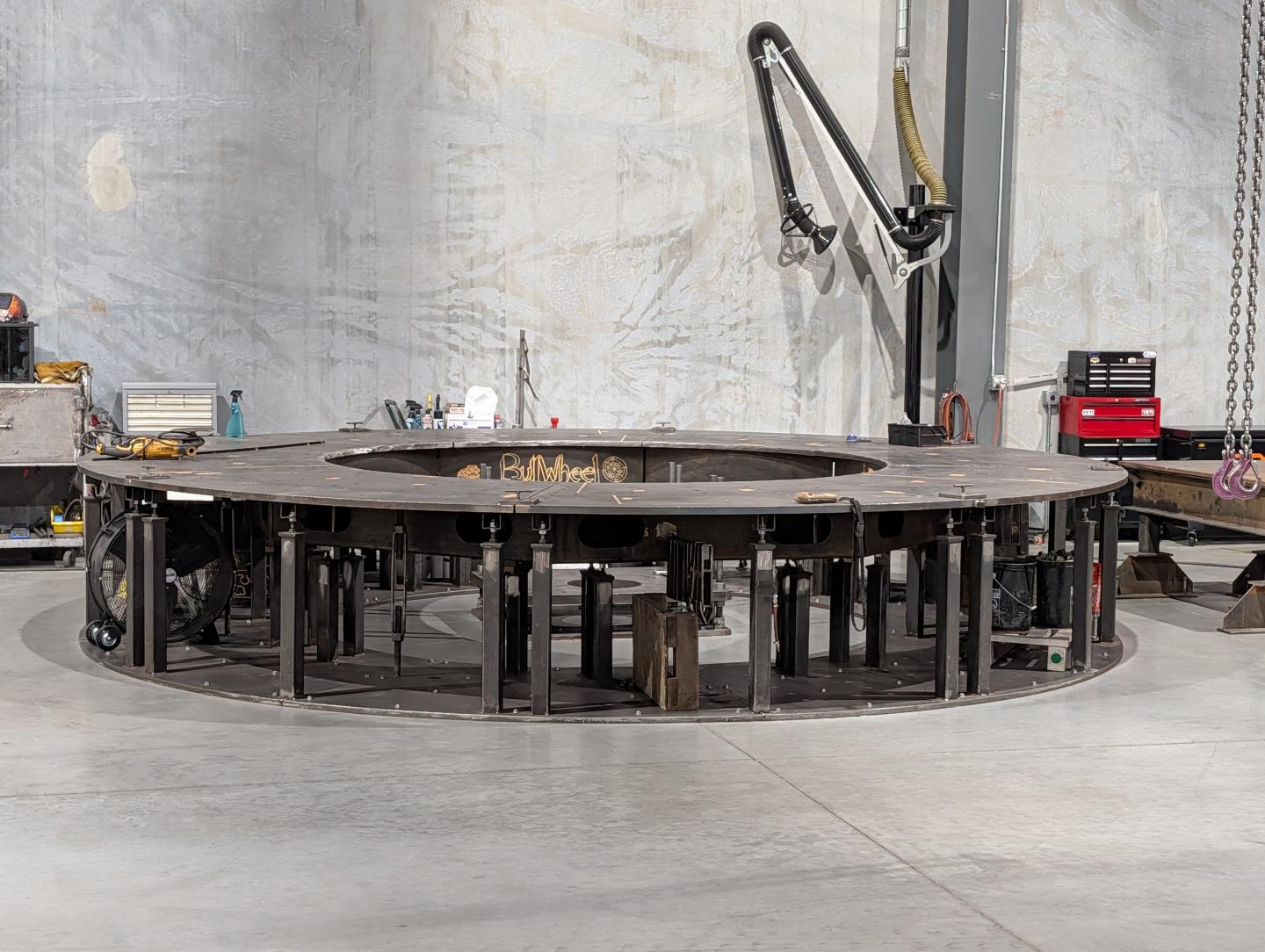 Large circular metal structure in an industrial workshop.