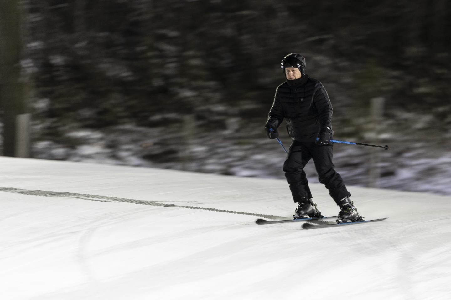 Man skiing downhill on a snowy slope.